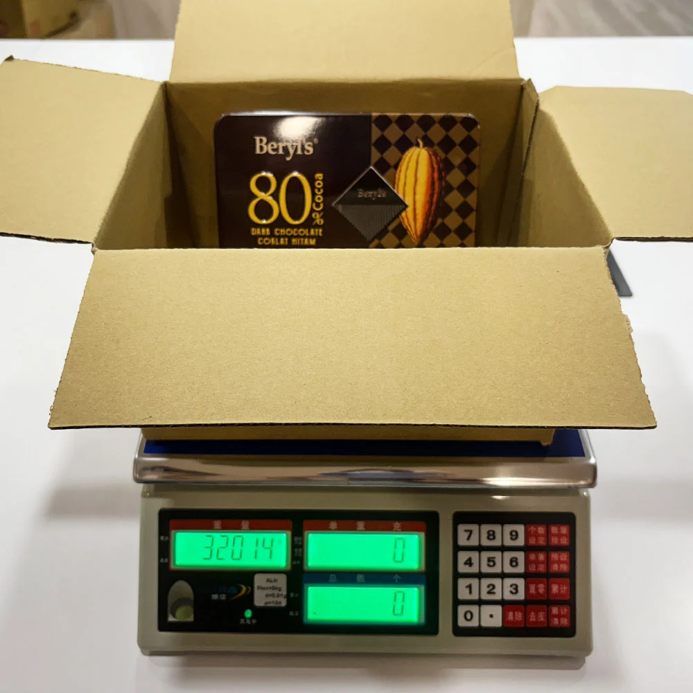 未使用額外填充材料的紙箱出貨重量測量畫面，顯示基準重量為320.14克，用於與其他包裝方式比較