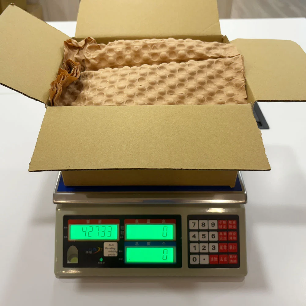 使用紙材進行填充後的出貨重量測量畫面，顯示在相同防護需求下整體重量為427.33克，反映材料使用量增加的結果